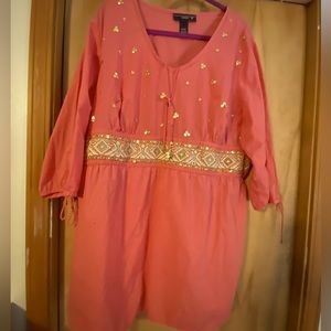 Salmon colored tunic with gold embellishments.